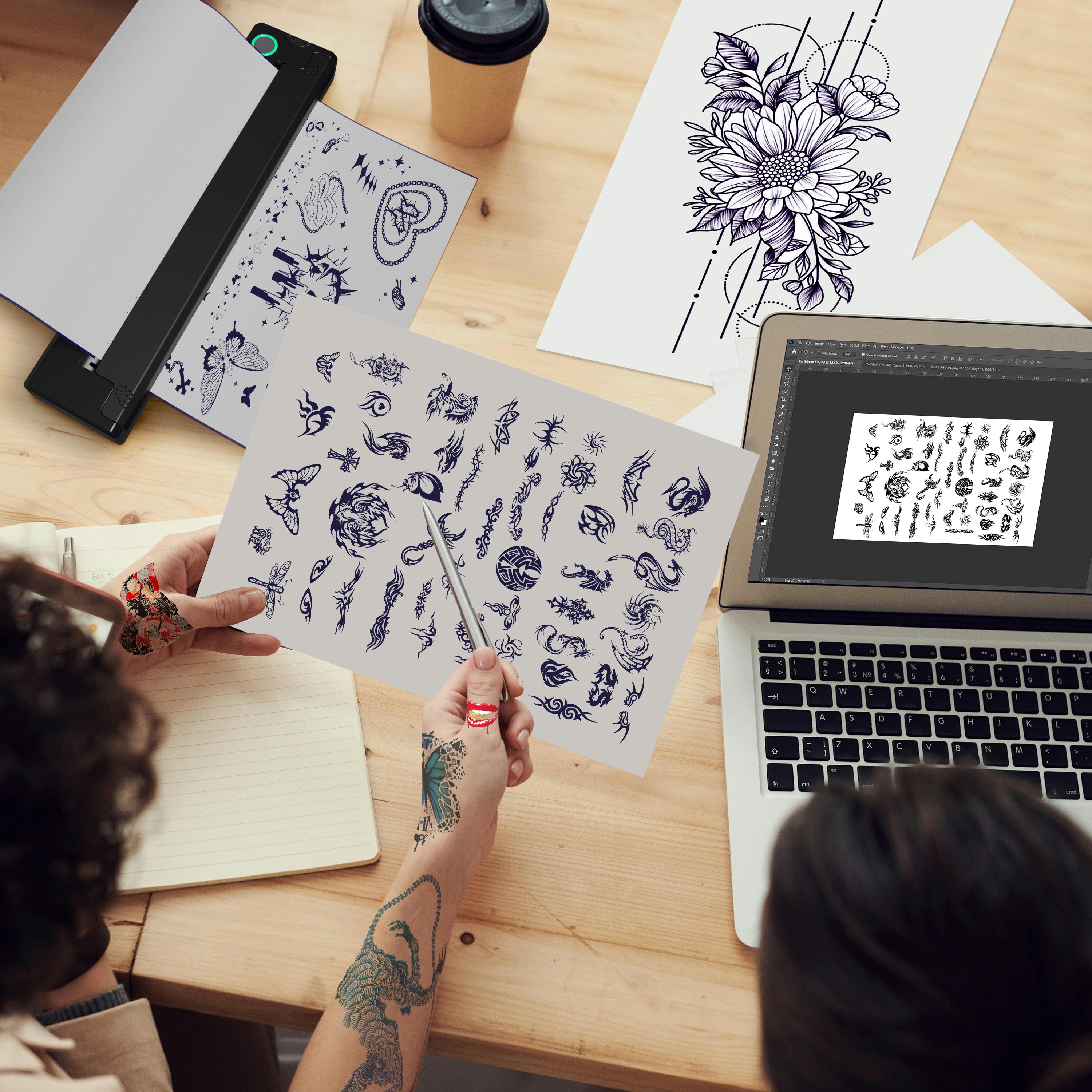 Tattoo artists preparing and printing multiple tattoo designs with PeriPage P90 Tattoo Stencil Printer connected to a laptop, surrounded by printed tattoo pattern sheets.