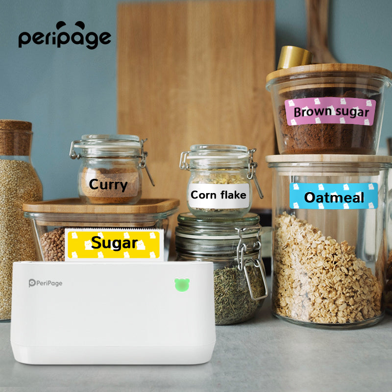 PeriPage A9 Max portable label printer used for kitchen jars, printing “Sugar”, “Curry”, and “Oatmeal” labels